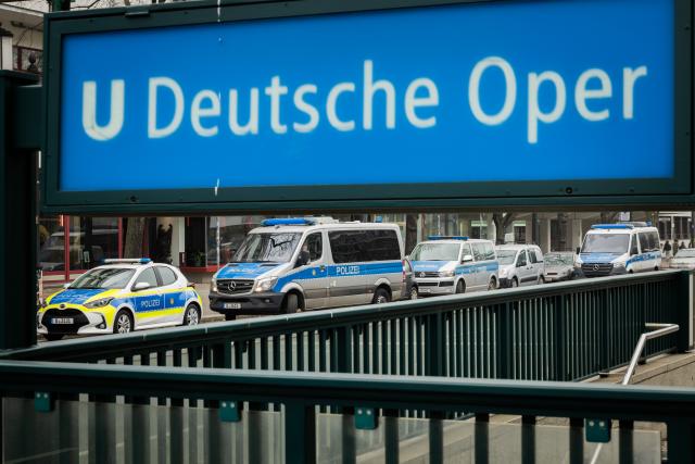 24 January 2026, Berlin: Police vehicles are parked near the entrance to the Deutsche Oper subway station. A teenager suffered a fatal electric shock in a Berlin subway station when he tried to retrieve his fallen e-cigarette from the track bed. Photo: Christoph Soeder/dpa