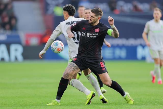 24 January 2026, North Rhine-Westphalia, Leverkusen: Leverkusen's Robert Andrich (R) and Bremen's Justin Njinmah battle for the ball during the German Bundesliga soccer match between Bayer Leverkusen and Werder Bremen at BayArena. Photo: Rolf Vennenbernd/dpa - WICHTIGER HINWEIS: Gemäß den Vorgaben der DFL Deutsche Fußball Liga bzw. des DFB Deutscher Fußball-Bund ist es untersagt, in dem Stadion und/oder vom Spiel angefertigte Fotoaufnahmen in Form von Sequenzbildern und/oder videoähnlichen Fotostrecken zu verwerten bzw. verwerten zu lassen.