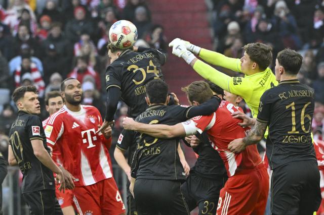 24 January 2026, Bavaria, Munich: Players from FC Bayern Munich and FC Augsburg battle for the ball during the German Bundesliga soccer match between FC Bayern Munich and FC Augsburg at Allianz Arena. Photo: Peter Kneffel/dpa - WICHTIGER HINWEIS: Gemäß den Vorgaben der DFL Deutsche Fußball Liga bzw. des DFB Deutscher Fußball-Bund ist es untersagt, in dem Stadion und/oder vom Spiel angefertigte Fotoaufnahmen in Form von Sequenzbildern und/oder videoähnlichen Fotostrecken zu verwerten bzw. verwerten zu lassen.