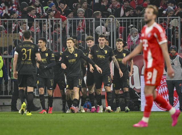 24 January 2026, Bavaria, Munich: Augsburg players celebrate their side's second goal during the German Bundesliga soccer match between FC Bayern Munich and FC Augsburg at Allianz Arena. Photo: Peter Kneffel/dpa - WICHTIGER HINWEIS: Gemäß den Vorgaben der DFL Deutsche Fußball Liga bzw. des DFB Deutscher Fußball-Bund ist es untersagt, in dem Stadion und/oder vom Spiel angefertigte Fotoaufnahmen in Form von Sequenzbildern und/oder videoähnlichen Fotostrecken zu verwerten bzw. verwerten zu lassen.