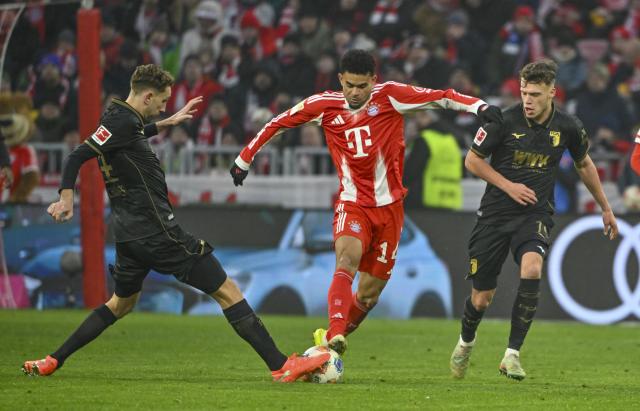 24 January 2026, Bavaria, Munich: Bayern Munich's Luis Diaz (C) battles for the ball with Augsburg's Robin Fellhauer (R) and Arthur Chaves during the German Bundesliga soccer match between FC Bayern Munich and FC Augsburg at Allianz Arena. Photo: Peter Kneffel/dpa - WICHTIGER HINWEIS: Gemäß den Vorgaben der DFL Deutsche Fußball Liga bzw. des DFB Deutscher Fußball-Bund ist es untersagt, in dem Stadion und/oder vom Spiel angefertigte Fotoaufnahmen in Form von Sequenzbildern und/oder videoähnlichen Fotostrecken zu verwerten bzw. verwerten zu lassen.
