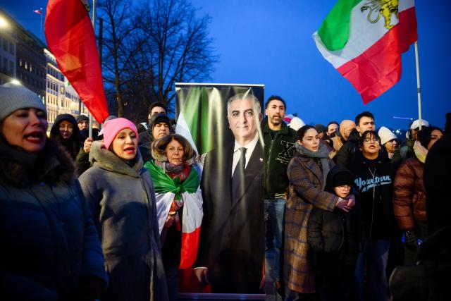 24 January 2026, Hamburg: People stand next to a display showing a portrait of the son of Iran's last shah, Reza Pahlavi, during a protest at the Binnenalster against the Iranian government and religious leaders and in solidarity with the recent protests in the Islamic country. Photo: Gregor Fischer/dpa