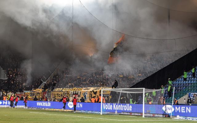 FILED - 24 January 2026, Saxony-Anhalt, Magdeburg: Dynamo Dresden fans set off pyrotechnics during the German second Bundesliga soccer match between 1. FC Magdeburg and Dynamo Dresden at Avnet Arena. At least 64 police officers have been injured in violent incidents around a German second division football match between Magdeburg and Dynamo Dresden. Photo: Andreas Gora/dpa