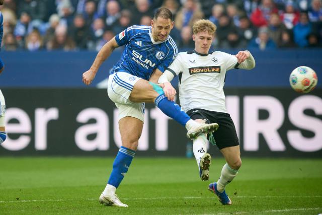 25 January 2026, North Rhine-Westphalia, Gelsenkirchen: Schalke's Nikola Katic and Kaiserslautern's Mika Haas battle for the ball during the German 2nd Bundesliga soccer match between FC Schalke 04 and 1. FC Kaiserslautern at Veltins Arena. Photo: Bernd Thissen/dpa - WICHTIGER HINWEIS: Gemäß den Vorgaben der DFL Deutsche Fußball Liga bzw. des DFB Deutscher Fußball-Bund ist es untersagt, in dem Stadion und/oder vom Spiel angefertigte Fotoaufnahmen in Form von Sequenzbildern und/oder videoähnlichen Fotostrecken zu verwerten bzw. verwerten zu lassen.