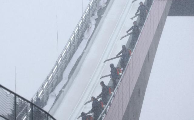 25 January 2026, Bavaria, Oberstdorf: Staff blow snow off the ski jump ahead of the men's team flying trial run at the Nordic Skiing/Ski Jumping World Championships. Photo: Karl-Josef Hildenbrand/dpa