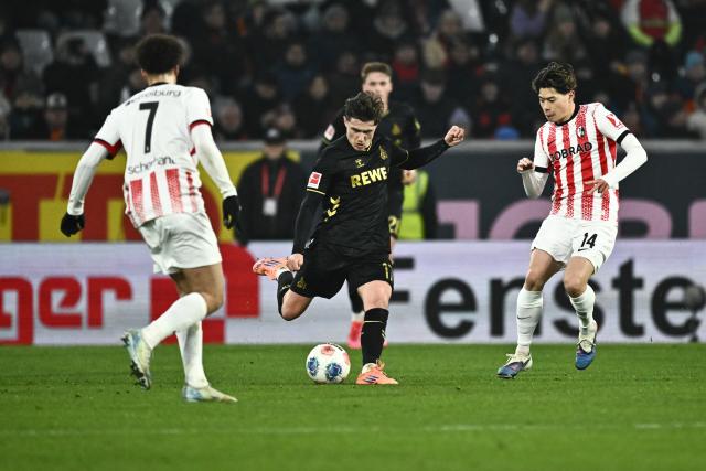 25 January 2026, Baden-Wuerttemberg, Freiburg im Breisgau: Cologne's Alessio Castro-Montes (C) battles for the ball with Freiburg's Derry Scherhant (L) and Freiburg's Yuito Suzuki during the German Bundesliga soccer match between SC Freiburgand FC Cologne at Europa-Park Stadium. Photo: Silas Stein/dpa - WICHTIGER HINWEIS: Gemäß den Vorgaben der DFL Deutsche Fußball Liga bzw. des DFB Deutscher Fußball-Bund ist es untersagt, in dem Stadion und/oder vom Spiel angefertigte Fotoaufnahmen in Form von Sequenzbildern und/oder videoähnlichen Fotostrecken zu verwerten bzw. verwerten zu lassen.