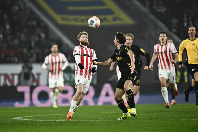 25 January 2026, Baden-Wuerttemberg, Freiburg im Breisgau: Freiburg's Niklas Beste (L) and Cologne's Jakub Kaminski battle for the ball during the German Bundesliga soccer match between SC Freiburgand FC Cologne at Europa-Park Stadium. Photo: Silas Stein/dpa - WICHTIGER HINWEIS: Gemäß den Vorgaben der DFL Deutsche Fußball Liga bzw. des DFB Deutscher Fußball-Bund ist es untersagt, in dem Stadion und/oder vom Spiel angefertigte Fotoaufnahmen in Form von Sequenzbildern und/oder videoähnlichen Fotostrecken zu verwerten bzw. verwerten zu lassen.