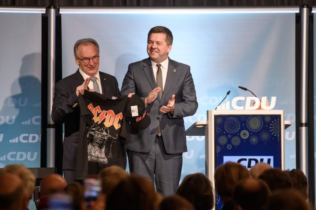 26 January 2026, Saxony-Anhalt, Magdeburg: Reiner Haseloff (L), Saxony-Anhalt Minister President, stands next to Sven Schulze, Saxony-Anhalt's Minister for Economic Affairs, Tourism, Agriculture, and Forestry, CDU state chairman, and leading candidate for the 2026 state election, at the New Year's reception of CDU Saxony-Anhalt and the CDU district association of Magdeburg, holding a shirt from the hard rock band AC/DC. Photo: Klaus-Dietmar Gabbert/dpa