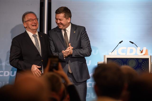 26 January 2026, Saxony-Anhalt, Magdeburg: Reiner Haseloff (L), Saxony-Anhalt Minister President, stands next to Sven Schulze, Saxony-Anhalt's Minister for Economic Affairs, Tourism, Agriculture, and Forestry, CDU state chairman, and leading candidate for the 2026 state election, at the New Year's reception of CDU Saxony-Anhalt and the CDU district association of Magdeburg, holding a shirt from the hard rock band AC/DC. Photo: Klaus-Dietmar Gabbert/dpa