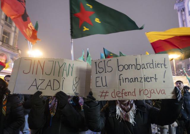 26 January 2026, Hesse, Frankfurt/Main: A sign reading 'ISIS bombs - EU finances! #defend rojava' is seen at a demonstration in the city center against the Syrian government and the Turkish government. Photo: Boris Roessler/dpa