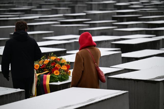 27 January 2026, Berlin: Visitors walk past a wreath placed on a stele at the Memorial to the Murdered Jews of Europe on International Holocaust Memorial Day in Memory of the Victims. Photo: Sebastian Gollnow/dpa