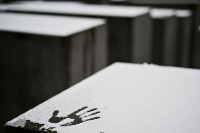 27 January 2026, Berlin: A handprint can be seen in the snow on a stele at the Memorial to the Murdered Jews of Europe on International Holocaust Memorial in Memory of the Victims. Photo: Sebastian Gollnow/dpa