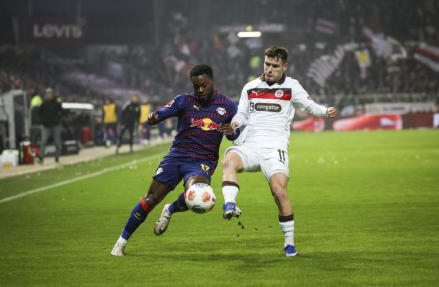 27 January 2026, Hamburg: Leipzig's Ridle Baku (L) and Pauli's Arkadiusz Pyrka battle for the ball during the German Bundesliga soccer match between FC St. Pauli and RB Leipzig at the Millerntor-Stadion. Photo: Christian Charisius/dpa - IMPORTANT NOTE: In accordance with the regulations of the DFL German Football League and the DFB German Football Association, it is prohibited to utilize or have utilized photographs taken in the stadium and/or of the match in the form of sequential images and/or video-like photo series.