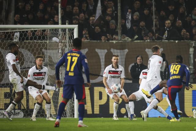 27 January 2026, Hamburg: Leipzig's Yan Diomande (R) scores his side's first goal during the German Bundesliga soccer match between FC St. Pauli and RB Leipzig at the Millerntor-Stadion. Photo: Christian Charisius/dpa - IMPORTANT NOTICE: DFL and DFB regulations prohibit any use of photographs as image sequences and/or quasi-video.