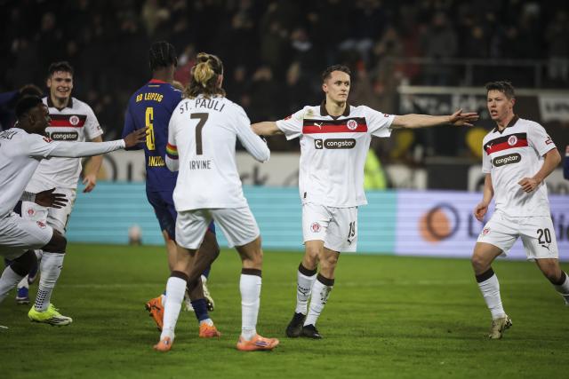 27 January 2026, Hamburg: Leipzig's Willi Orban (R) and Pauli's Ricky Jade-Jones battle for the ball during the German Bundesliga soccer match between FC St. Pauli and RB Leipzig at the Millerntor-Stadion. Photo: Christian Charisius/dpa - IMPORTANT NOTICE: DFL and DFB regulations prohibit any use of photographs as image sequences and/or quasi-video.