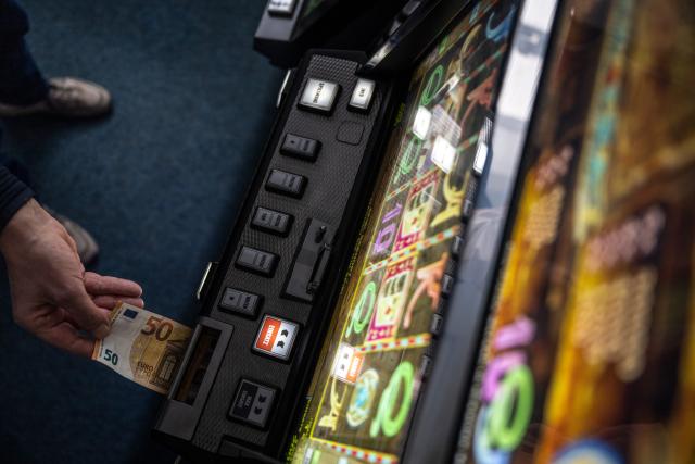FILED - 04 February 2022, Unna: A banknote is pushed into a slot machine. Photo: Bernd Thissen/dpa