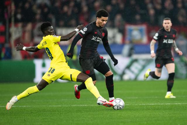 28 January 2026, North Rhine-Westphalia, Leverkusen: Bayer Leverkusen's Malik Tillman (R) and Villarreal's Diatta Alassane battle for the ball during the UEFA Champions League soccer match between Bayer Leverkusen and Villarreal CF at BayArena. Photo: Marius Becker/dpa