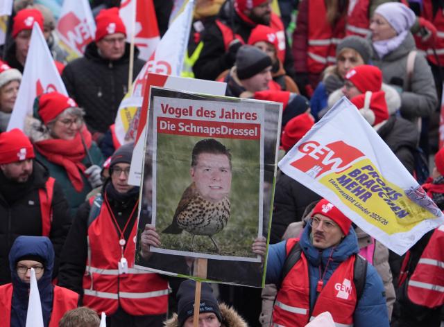 29 January 2026, Hamburg: Public sector employees demonstrate during a warning strike and hold up a poster with the portrait of Hamburg's Finance Senator Dressel. The Education and Science Union (GEW) has called for a nationwide "Education Strike Day". Photo: Marcus Brandt/dpa