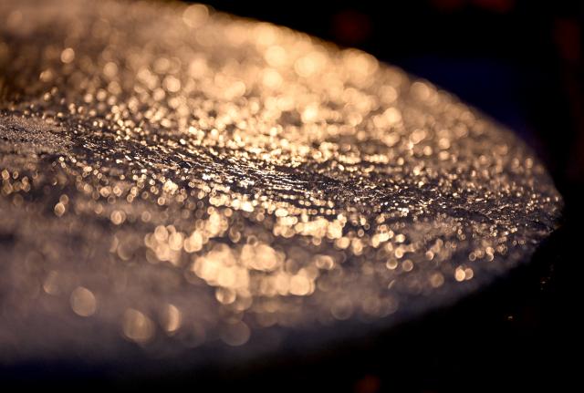 30 January 2026, Berlin: An icy surface glistens in the light of a lantern. Photo: Britta Pedersen/dpa