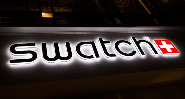 FILED - 17 February 2016, Bavaria, Munich: The Swatch logo shines on the facade of the Swatch store in Munich. Photo: Peter Kneffel/dpa