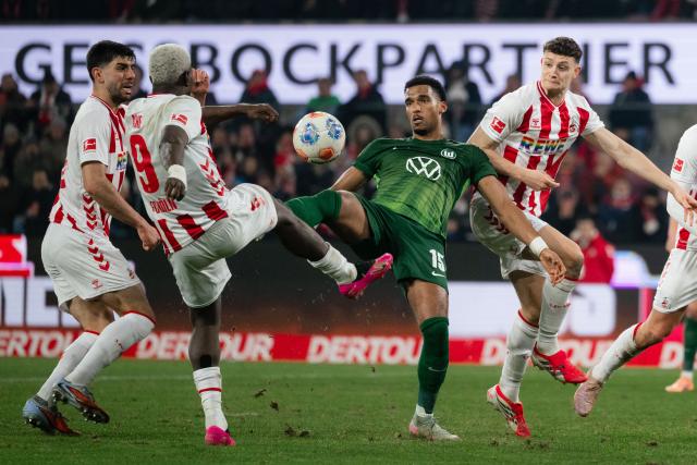 30 January 2026, North Rhine-Westphalia, Cologne: Cologne's Ragnar Ache (2nd L) and Wolfsburg's Moritz Jenz (3rd L) battle for the ballduring the German Bundesliga soccer match between 1. FC Cologne and VfL Wolfsburg at the RheinEnergieStadion. Photo: Marius Becker/dpa - IMPORTANT NOTICE: DFL and DFB regulations prohibit any use of photographs as image sequences and/or quasi-video.