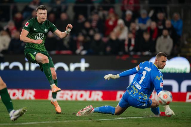 30 January 2026, North Rhine-Westphalia, Cologne: Wolfsburg's Dzenan Pejcinovic (L) misses against Cologne goalkeeper Marvin Schwaebe during the German Bundesliga soccer match between 1. FC Cologne and VfL Wolfsburg at the RheinEnergieStadion. Photo: Marius Becker/dpa - IMPORTANT NOTICE: DFL and DFB regulations prohibit any use of photographs as image sequences and/or quasi-video.