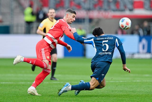 31 January 2026, Baden-Württemberg, Sinsheim: Berlin's Andrej Ilic (L) and Hoffenheim's Ozan Kabak battle for the ball during the German Bundesliga soccer match between TSG 1899 Hoffenheim and 1. FC Union Berlin at the PreZero Arena. Photo: Uwe Anspach/dpa - IMPORTANT NOTE: In accordance with the regulations of the DFL German Football League and the DFB German Football Association, it is prohibited to utilize or have utilized photographs taken in the stadium and/or of the match in the form of sequential images and/or video-like photo series.
