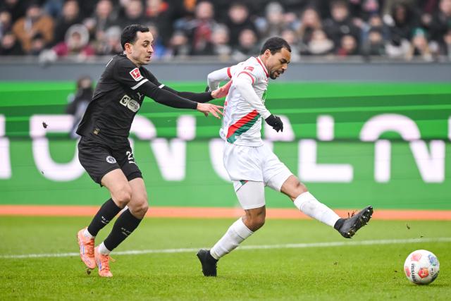 31 January 2026, Bavaria, Augsburg: St. Pauli's Manolis Saliakas (L) in action against Augsburg's Alexis Claude-Maurice during the German Bundesliga soccer match between FC Augsburg and FC St. Pauli at the WWK Arena. Photo: Harry Langer/dpa - IMPORTANT NOTICE: DFL and DFB regulations prohibit any use of photographs as image sequences and/or quasi-video.