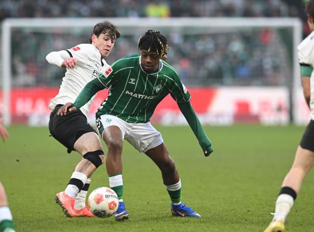 31 January 2026, Bremen: Bremen's Samuel Mbangula and Gladbach's Philipp Sander battle for the ball during the German Bundesliga soccer match between Werder Bremen and Borussia Moenchengladbach at the Weserstadion. Photo: Carmen Jaspersen/dpa - IMPORTANT NOTICE: DFL and DFB regulations prohibit any use of photographs as image sequences and/or quasi-video.