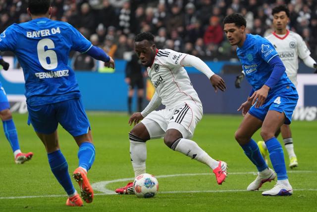 31 January 2026, Hesse, Frankfurt/M.: Frankfurt's Arnaud Kalimuendo battle for the ball with Leverkusen's Equi Fernandez and Jarell Quansah during the German Bundesliga soccer match between Eintracht Frankfurt and Bayer Leverkusen at the Deutsche Bank Park. Photo: Marc Schüler/dpa - IMPORTANT NOTICE: DFL and DFB regulations prohibit any use of photographs as image sequences and/or quasi-video.