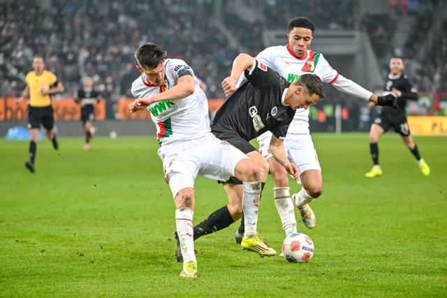 31 January 2026, Bavaria, Augsburg: Augsburg's Keven Schlotterbeck in action against St. Pauli's Martijn Kaars during the German Bundesliga soccer match between FC Augsburg and FC St. Pauli at the WWK Arena. Photo: Harry Langer/dpa - IMPORTANT NOTICE: DFL and DFB regulations prohibit any use of photographs as image sequences and/or quasi-video.