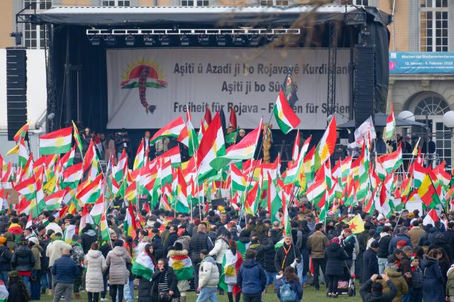 31 January 2026, North Rhine-Westphalia, Bonn: Participants hold flags and placards at a large rally in solidarity with the Kurdish people in Syria. Photo: Henning Kaiser/dpa