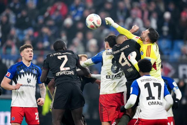 31 January 2026, Hamburg: Hamburger goalkeeper Daniel Heuer Fernandes (R) clears the ball during the German Bundesliga soccer match between Hamburger SV and FC Bayern Munich at the Volksparkstadion Photo: Marcus Brandt/dpa - IMPORTANT NOTICE: DFL and DFB regulations prohibit any use of photographs as image sequences and/or quasi-video.