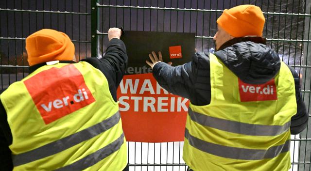 02 February 2026, Thuringia, Erfurt: Union members display a poster with the words "Warning strike" at the depot of Erfurter Verkehrsbetriebe AG. The trade union Verdi has called for warning strikes at municipal transport companies in almost all federal states on Monday as part of parallel wage negotiations. Photo: Martin Schutt/dpa
