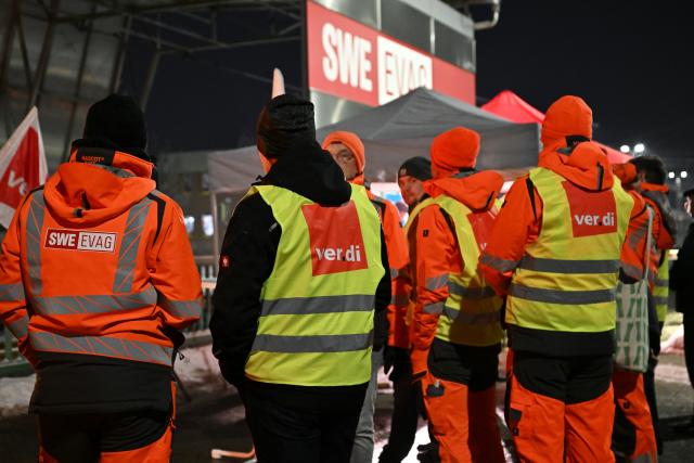 02 February 2026, Thuringia, Erfurt: Union members stand in front of the depot of Erfurter Verkehrsbetriebe AG. The trade union Verdi has called for warning strikes at municipal transport companies in almost all federal states on Monday as part of parallel wage negotiations. Photo: Martin Schutt/dpa
