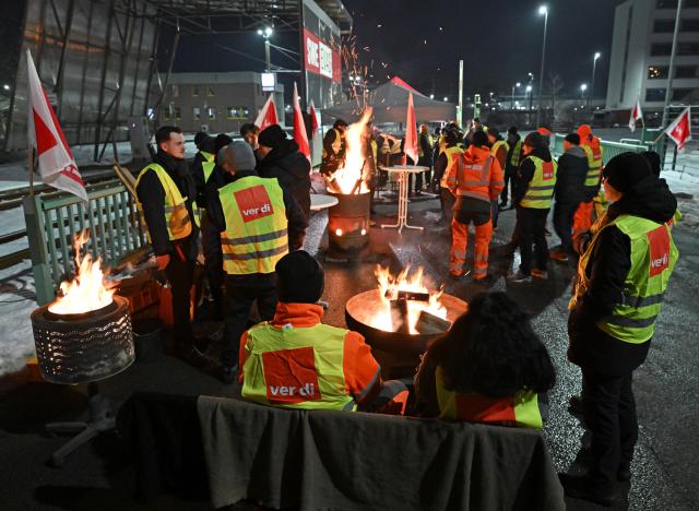 02 February 2026, Thuringia, Erfurt: Union members stand in front of the depot of Erfurter Verkehrsbetriebe AG. The Verdi trade union has called for warning strikes at municipal transport companies in almost all federal states on Monday as part of parallel wage negotiations. Photo: Martin Schutt/dpa