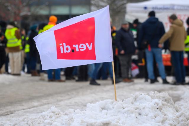 02 February 2026, Saxony-Anhalt, Magdeburg: A trade union flag is waving in the snow. Strikers have gathered behind it. The trade union "Verdi" had called an all-day warning strike. Among those affected are the Saxony-Anhalt State Road Construction Authority, Otto von Guericke University Magdeburg, Magdeburg-Stendal University of Applied Sciences, ministries and state offices of the state of Saxony-Anhalt as well as the federal government's Autobahn GmbH at the Magdeburg, Theessen, Börde, Wernigerode and Plötzkau sites. Photo: Klaus-Dietmar Gabbert/dpa