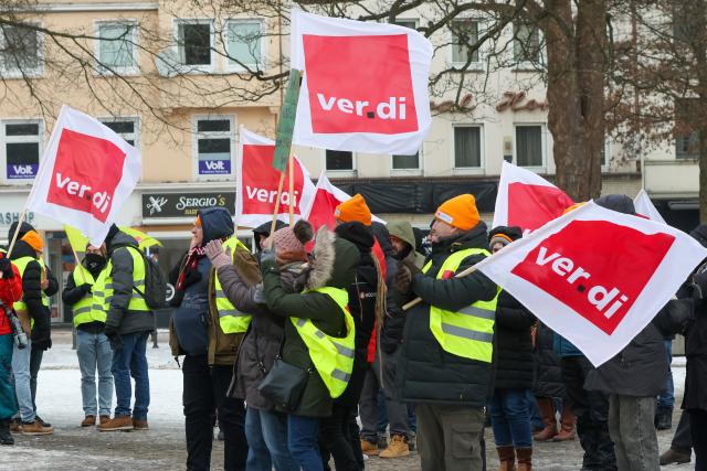 02 February 2026, Hamburg: Participants hold Verdi union flags at a rally in Hamburg-Harburg. The Verdi trade union has called for warning strikes at municipal transport companies in almost all federal states on Monday as part of parallel wage negotiations. Photo: Bodo Marks/dpa