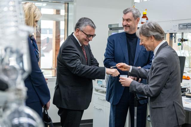 03 February 2026, Bavaria, Straubing: Markus Soeder (C), Minister President of Bavaria, and Florian Herrmann (L), Head of the Bavarian State Chancellery, listen to Volker Sieber, Rector of the TUM Campus, explain which products can be made from renewable raw materials. The Minister President visited a high-tech laboratory on the TUM Campus before the cabinet meeting. Photo: Armin Weigel/dpa