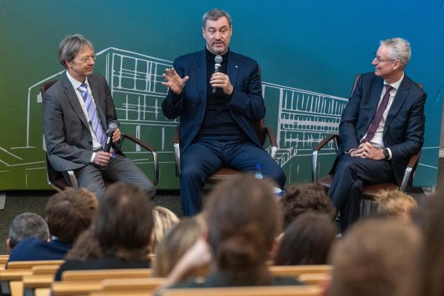 03 February 2026, Bavaria, Straubing: Markus Soeder (C), Minister President of Bavaria, speaks to students alongside Volker Sieber (L), Rector of the TUM Campus, and Markus Pannermayr, Lord Mayor of Straubing. The Minister President visited a high-tech laboratory on the TUM campus before the cabinet meeting. Photo: Armin Weigel/dpa