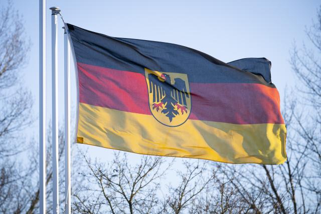 03 February 2026, Hamburg: The federal service flag flies at the entrance to the Hohe Düne barracks complex. Two men have been arrested. They are accused of attempted sabotage of a ship. Searches were carried out in several countries. Photo: Philip Dulian/dpa