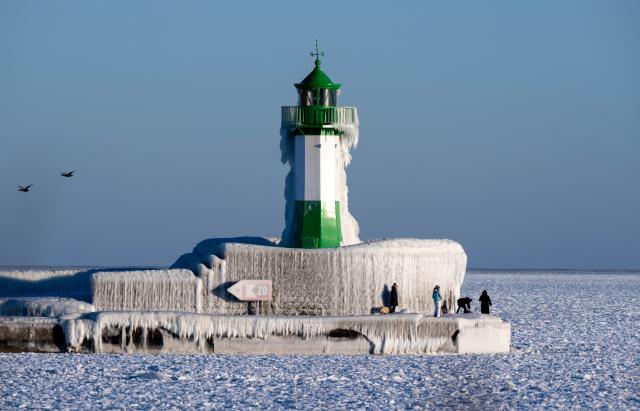 03 February 2026, Mecklenburg-Western Pomerania, Sassnitz: People enjoy the icicles on the pier with the pier light in the port city of Sassnitz on the island of Ruegen. Photo: Stefan Sauer/dpa