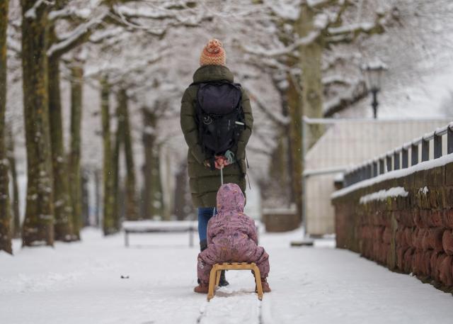 03 February 2026, Rhineland-Palatinate, Mainz: A woman pulls a child on a sled across the snow-covered Kupferberg terraces. Photo: Andreas Arnold/dpa