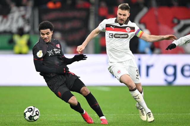 03 February 2026, North Rhine-Westphalia, Leverkusen: Bayer Leverkusen's Malik Tillman (L) and St. Pauli's Karol Mets battle for the ball during the German DFB Cup soccer match between Bayer Leverkusen and FC St. Pauli at BayArena. Photo: Federico Gambarini/dpa - IMPORTANT NOTICE: DFL and DFB regulations prohibit any use of photographs as image sequences and/or quasi-video.