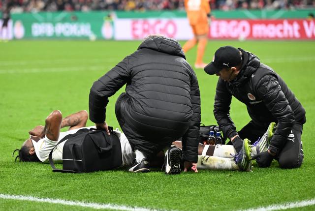 03 February 2026, North Rhine-Westphalia, Leverkusen: FC St. Pauli's Ricky-Jade Jones receives medical treatment on the pitch during the German DFB Cup soccer match between Bayer Leverkusen and FC St. Pauli at BayArena. Photo: Federico Gambarini/dpa - IMPORTANT NOTICE: DFL and DFB regulations prohibit any use of photographs as image sequences and/or quasi-video.