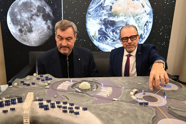 04 February 2026, Bavaria, Wessling: Bavarian Minister President Markus Soeder (L) and Josef Aschbacher, ESA Director General, view a model of a possible moon landing station at the OHB space company as part of the "MoonTalk" on the founding of the "European Moonport Company" for the development of high technologies for the moon. Photo: Felix Hörhager/dpa