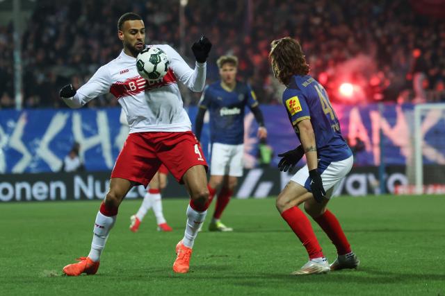 04 February 2026, Schleswig-Holstein, Kiel: Holstein Kiel's John Tolkin (R) and Stuttgart's Josha Vagnoman battle for the ball during the German DFB Cup quarterfinal soccer match between Holstein Kiel and VfB Stuttgart at Holstein Stadium. Photo: Christian Charisius/dpa - IMPORTANT NOTICE: DFL and DFB regulations prohibit any use of photographs as image sequences and/or quasi-video.