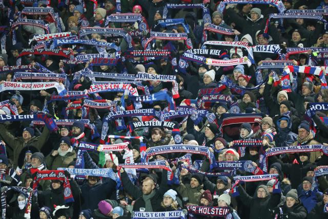 04 February 2026, Schleswig-Holstein, Kiel: Holstein Kiel fans cheer in the stands prior to the start of the German DFB Cup quarterfinal soccer match between Holstein Kiel and VfB Stuttgart at Holstein Stadium. Photo: Christian Charisius/dpa - IMPORTANT NOTICE: DFL and DFB regulations prohibit any use of photographs as image sequences and/or quasi-video.