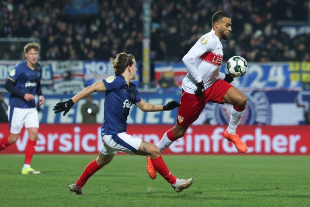 04 February 2026, Schleswig-Holstein, Kiel: Holstein Kiel's John Tolkin (L) and Stuttgart's Josha Vagnoman battle for the ball during the German DFB Cup quarterfinal soccer match between Holstein Kiel and VfB Stuttgart at Holstein Stadium. Photo: Christian Charisius/dpa - IMPORTANT NOTICE: DFL and DFB regulations prohibit any use of photographs as image sequences and/or quasi-video.
