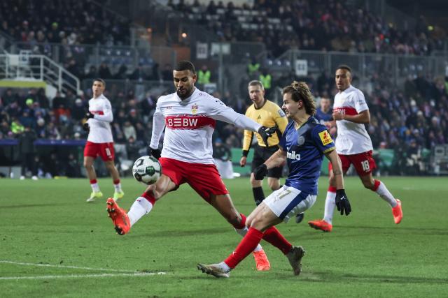 04 February 2026, Schleswig-Holstein, Kiel: Stuttgart's Josha Vagnoman (L) and Holstein Kiel's John Tolkin battle for the ball during the German DFB Cup quarterfinal soccer match between Holstein Kiel and VfB Stuttgart at Holstein Stadium. Photo: Christian Charisius/dpa - IMPORTANT NOTICE: DFL and DFB regulations prohibit any use of photographs as image sequences and/or quasi-video.